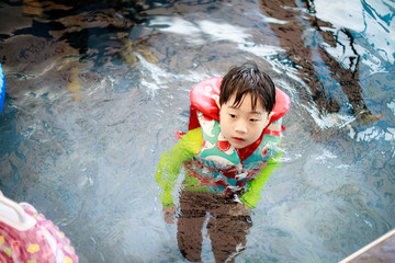 Wall Mural - Cute little boy having fun in the swimming pool