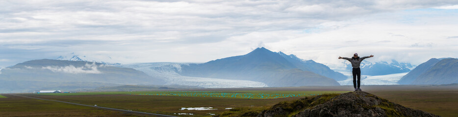 Panorama picture of asian woman solo travel enjoy at nature on the top mountain with Skaftafellsjokull glacier as a Background in Iceland