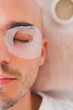 © Photoboyko - Man with moisturizing mask for skin around the eyes. Male grooming, taking self care concept: applying treatment to skin around the eyes