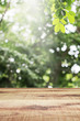 Wooden table and blurred green leaves nature bokeh background. 