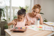 © makistock - Young Asian beautiful mom with her daughter kid painting at home.