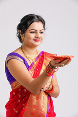 Wall Mural - Indian woman in traditional sari and holding oil lamp in Hand celebrating Diwali or deepavali, fesitval. 