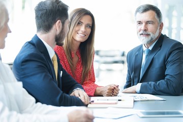 Canvas Print - Group of confident business partners interacting at meeting