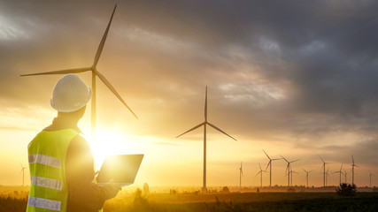 silhouette of technician engineer at wind turbine electricity industrial in sunset