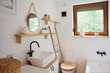 Rustic vintage style of bathroom in white color and wooden decor. Small bathroom with washbasin and window in a cottage.