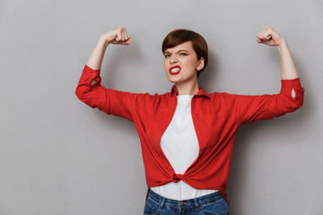 Poster - Image of strong brunette woman wearing casual clothes showing her biceps