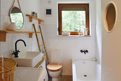 Fotografía interior of small modern bathroom in white color and wooden decor