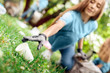 © Viktoriia - Volunteering. Young people volunteers outdoors girl close-up picking plastic cup blurred background smiling happy