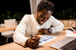 © LIGHTFIELD STUDIOS - happy african american businessman looking at graphs and charts while working at night in office
