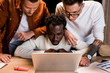© LIGHTFIELD STUDIOS - attentive multicultural businesspeople looking at laptop while working at night in office