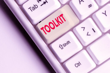 Conceptual hand writing showing Toolkit. Concept meaning set of tools kept in a bag or box and used for a particular purpose White pc keyboard with note paper above the white background