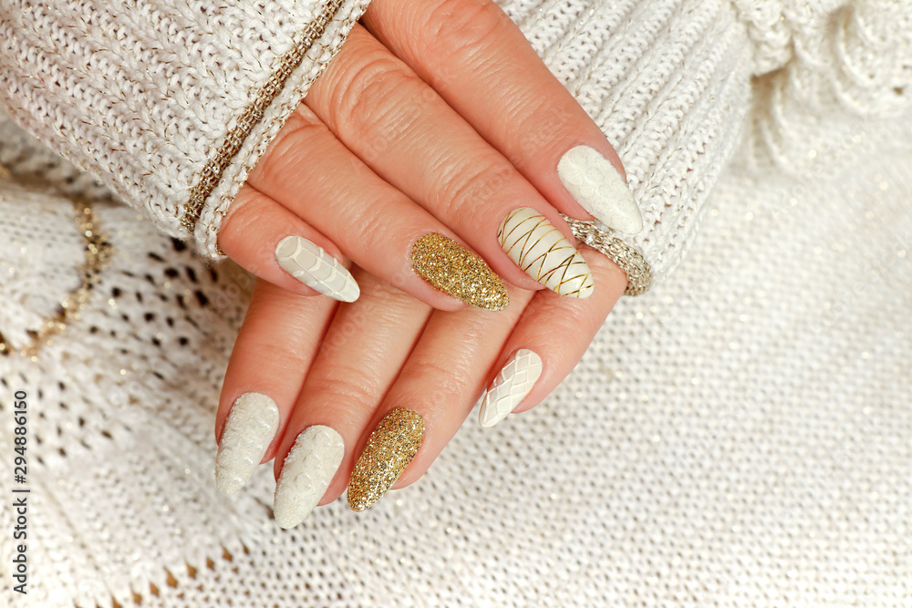 Αφίσα Knitted sand manicure on long oval nails with golden sequins and threads on the female red in a jacket