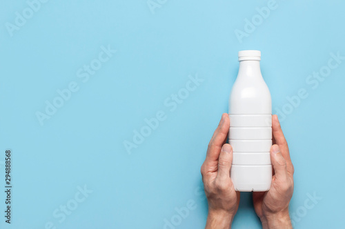 Download White Plastic Bottle Containers For Dairy Products In Male Hands On Blue Background Top View Flat Lay Plastic Kefir Yogurt Milk Bottle Packaging Template Mockup Layout For Your Design Buy This PSD Mockup Templates