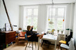 © FOLIO - Young woman sitting with feet up in apartment