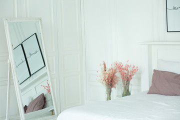 Wall Mural - Spring floral interiors, with rabbits and soft armchairs,delicate and romantic bedroom interior, fresh flowers on bedside table, metal lamp and open book placed on bed with pastel bedding