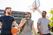 © Syda Productions - sport, leisure games and male friendship concept - group of men or friends going to play basketball outdoors