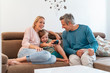 © Westend61 - Happy parents with son playing video game on couch at home