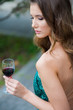 Elegant young woman in evening dress with a glass of wine