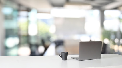 Workspace with laptop computer and coffee cup on table.