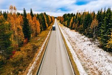 Aerial View Of First Snow Autumn Color Forest And A Road With Car In Finland.