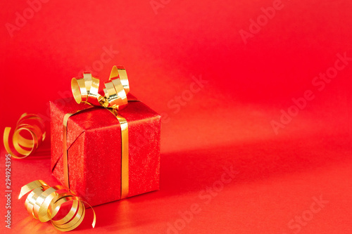 Red gift box on red background.