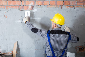 Builder is plastering the wall