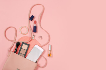 Wall Mural - Fashion concept : Flat lay of brown leather woman bag open out with cosmetics, accessories and smartphone on pink background