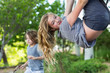© Mint Images - Portrait of teenage girl hanging outdoors with brother in background