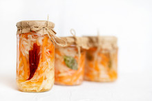 Three Jars Of Sauerkraut And Carrots In Its Own Juice With Spices, White Wooden Table. Traditional Home-made, Fermented Dish Of Russia And Germany.