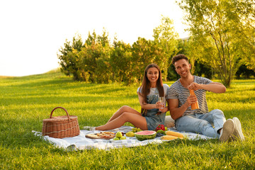 Wall Mural - Happy couple having picnic in park on sunny day