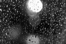 Black And White Mood And Tone, Close Up And Macro View Of Raining Water Drop On Glass Window And Blur Background With Circle Round Light Bokeh. 