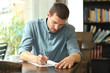 © Antonioguillem - Concentrated man writing notes in a paper in a coffee shop