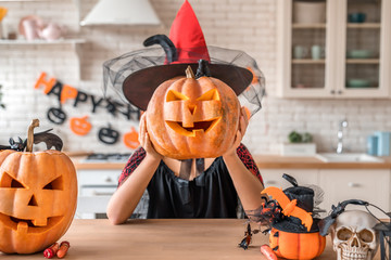 Beautiful woman in witch costume with pumpkins near her head. Happy Halloween concept!