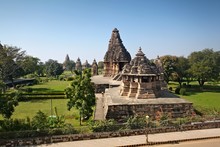 Khajuraho Temples In India Surrounded By Green Trees And Flowers