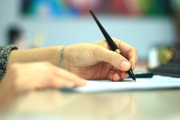 Businesswoman writing to notepad in office