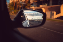 The Perth City Skyline In The Sideview Mirror Of A Car. Beautiful And Quiet Sunrise Over The City With Golden Light. 
