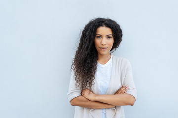 Young woman with folded arms staring at camera