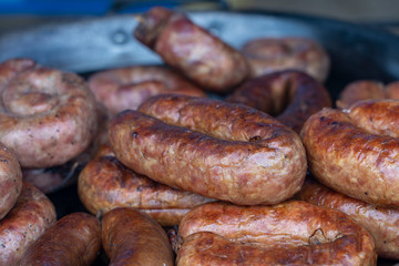 Fried sausages for sell in street food market, Ukraine, closeup