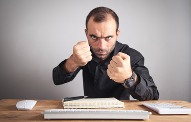 Wall Mural - Caucasian angry man looking in camera threatening with fists.