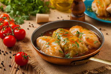 Wall Mural - Traditional stuffed cabbage with minced meat and rice, served in a tomato sauce.