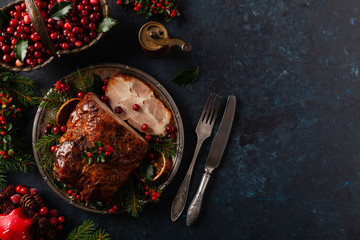 roast pork neck in christmas style. dark navy blue background. christmas accessories. top view.