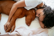 Close Up Young Woman Sleeping With Dog In Bed