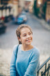 © Erika - Little girl in an urban setting smiles at the camera.