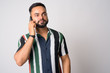 © Ranta Images - Portrait of young handsome bearded Indian man talking on the phone
