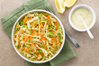 © Ildi - Coleslaw made of freshly shredded white cabbage and grated carrot with homemade mayonnaise-based salad dressing and lemon wedges on the side, photographed overhead (Selective Focus on the salad)