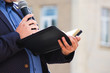 A preacher with a microphone in his hand holds a Bible and reads a passage from it_
