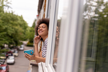 Wall Mural - Woman drinking coffee by the window