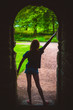 canvas print picture - Silhouette of a Girl Leaving a Stone Archway Going into Nature