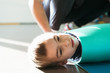 © Ivan - Happy little boy is playing in a yoga carpet. With his mommy on the background. Having fun rolling on the floor.