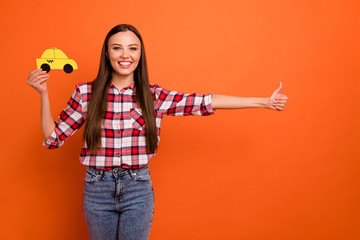 Hailing taxi concept. Photo of satisfied with beaming smile lady raising thumb up to catch the yellow car isolated bright color background